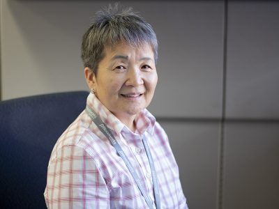 Photo of a woman sitting at her desk and smiling